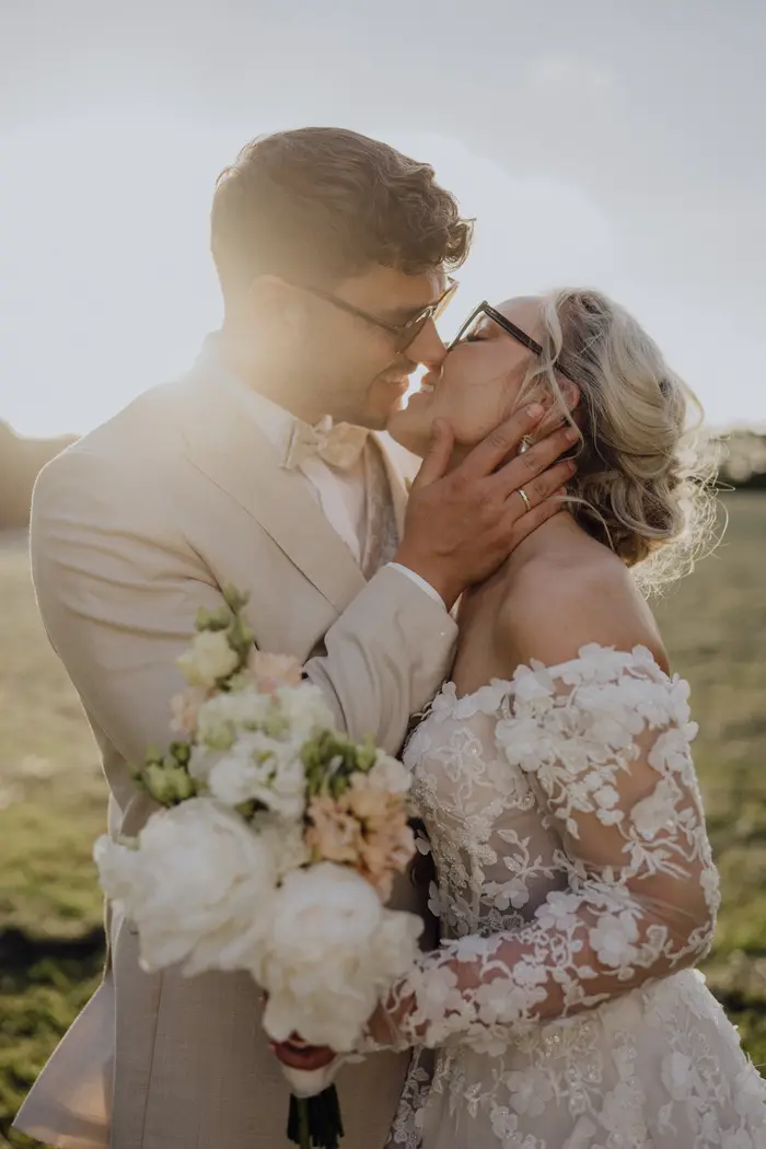Marleen und Jendrik küssen sich mit Brille im warmen Gegenlicht.